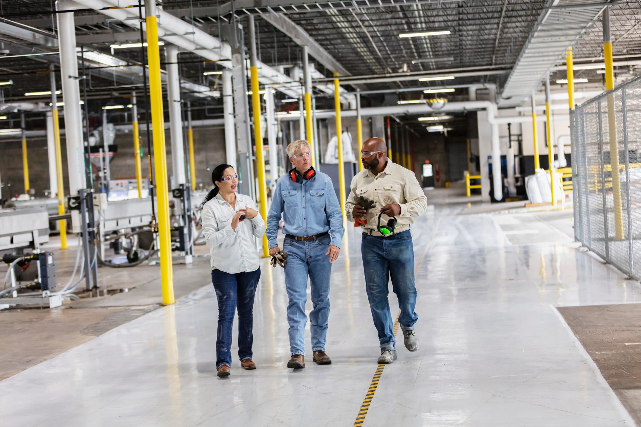 Engineering team walking and discussing work on a factory floor